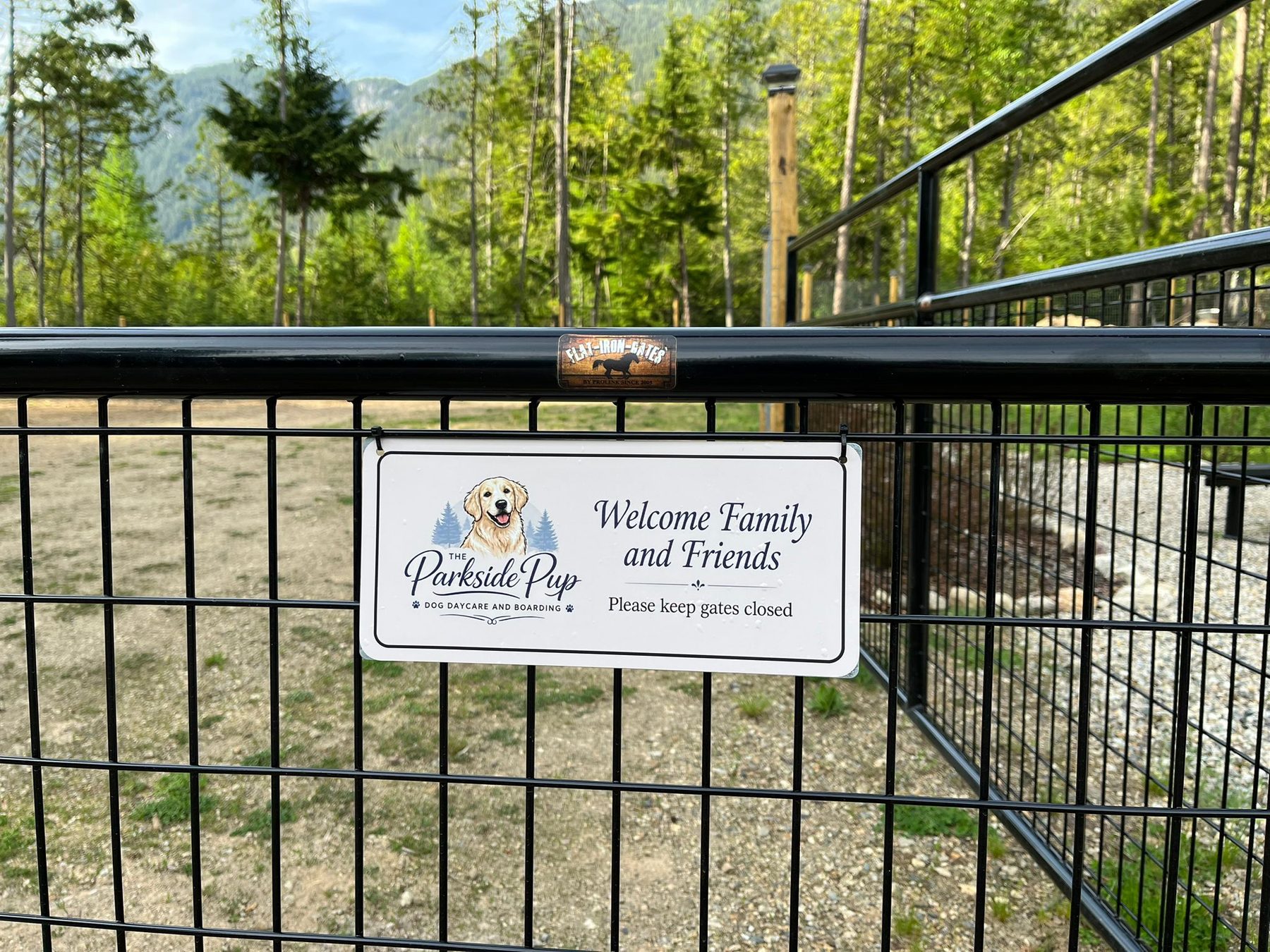 Welcome sign at the Parkside Pup gate with mountain backdrop